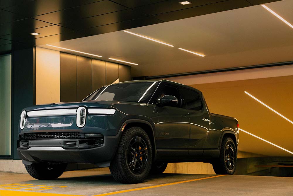 Rivian R1T driving out of a garage