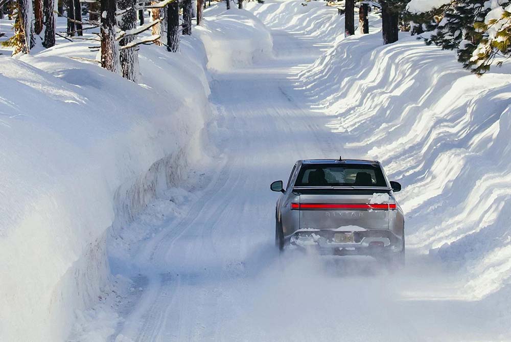 Silver pickup truck driving through the snow