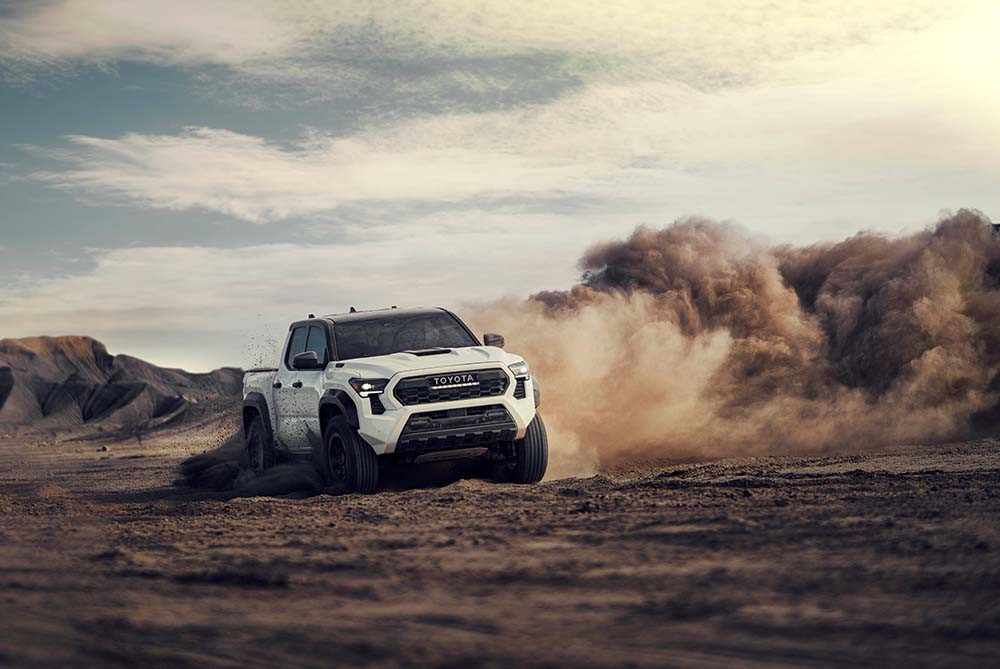 Toyota Tacoma driving through a dusty terrain