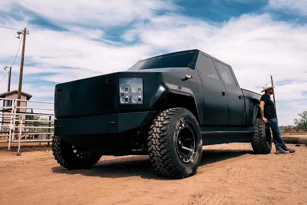 A huge Matte Black pickup truck parked up at a ranch