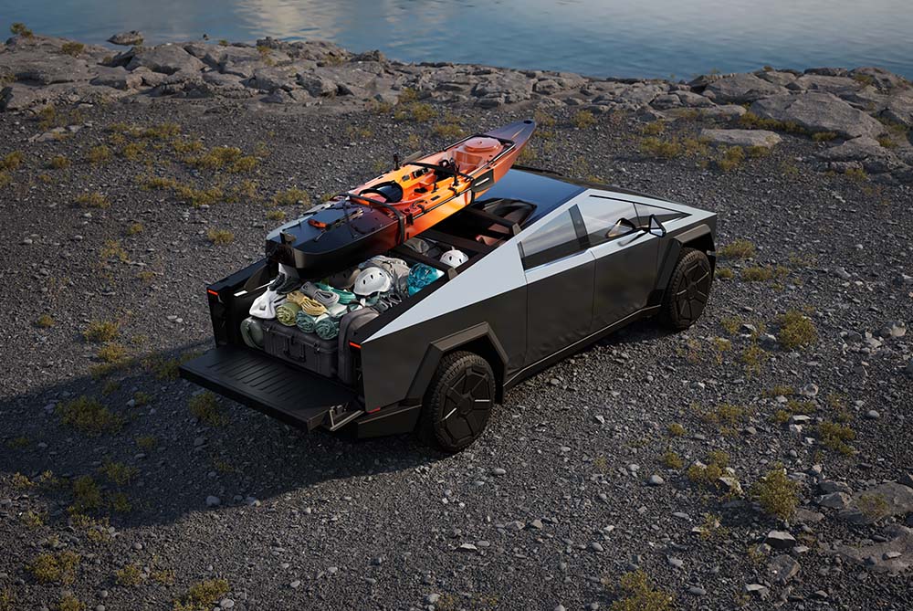 Tesla Cybertruck packed with luggage and a canoe on the roof