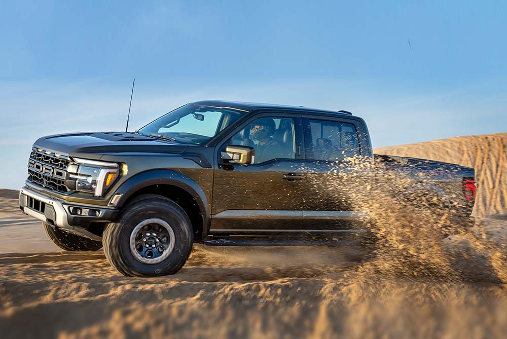 Ford pickup truck kicking up sand