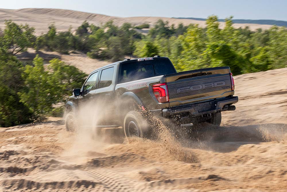 Ford F-150 driving downhill on a sandy track