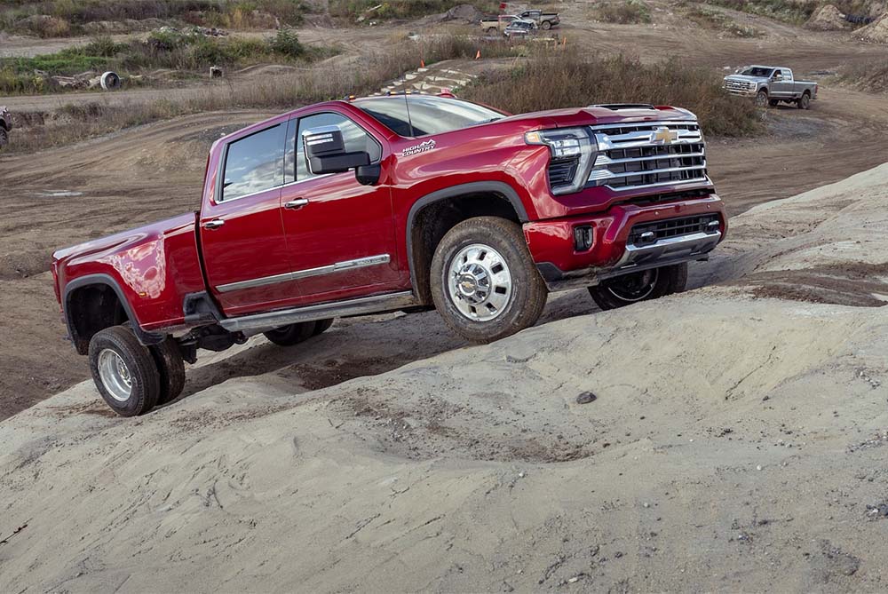 Red Chevrolet driving up a boulder