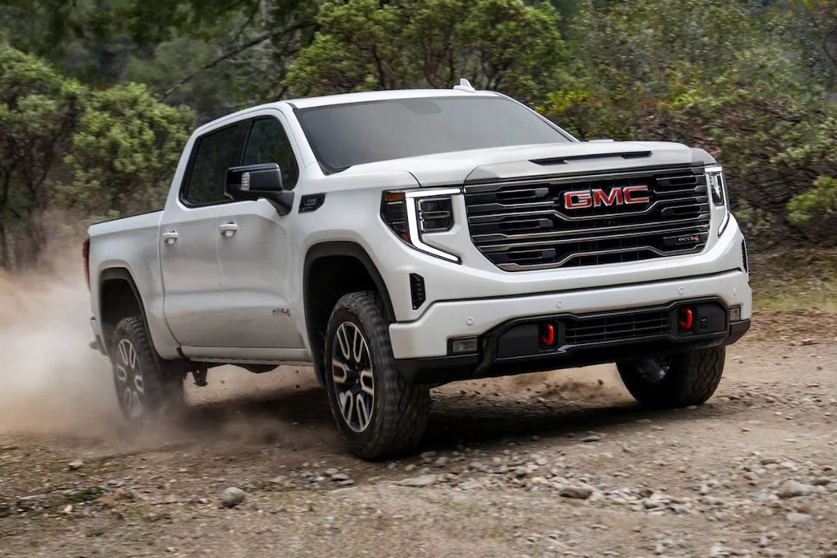 A sleek white GMC Sierra truck on an off-road trail