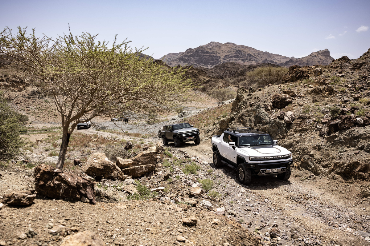 A trail of GMC Hummer driving over a rocky terrain