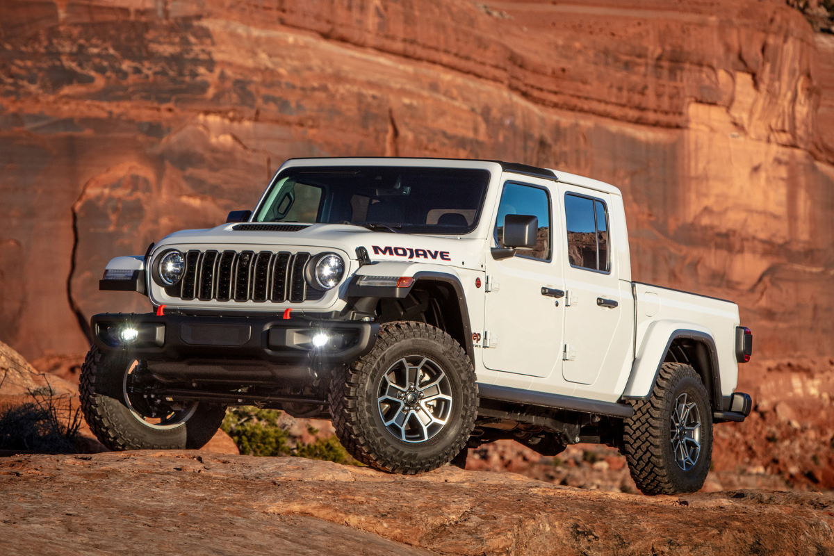 A white Jeep Gladiator parked on a mountain