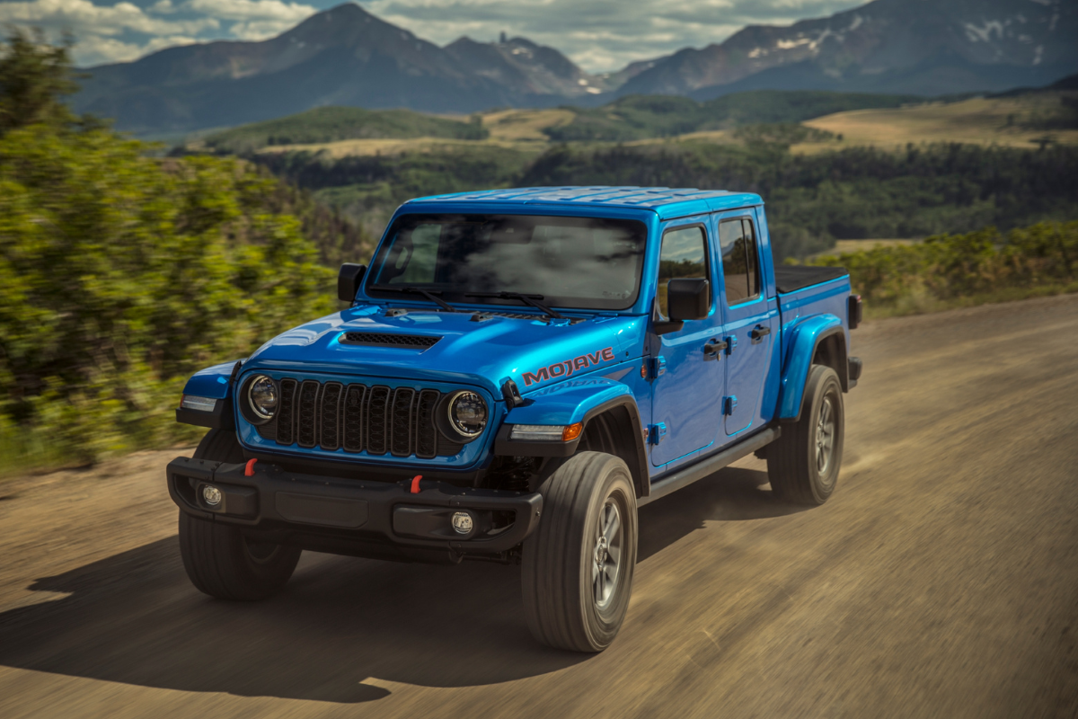 A Blue Jeep Gladiator driving on a country road